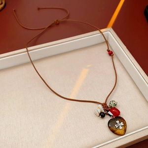 Detail of heart-shaped stone pendant with silver cross and colorful wooden beads
