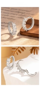 Macro detail of silver hoop earrings featuring five square-cut clear cubic zirconia stones