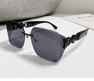 Detail of dark gray rimless sunglasses with embossed circular temple decoration