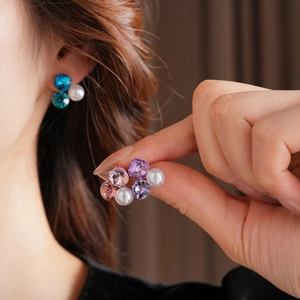 Detailed macro shot of vintage-style triangle pearl earrings with sparkling crystal clusters
