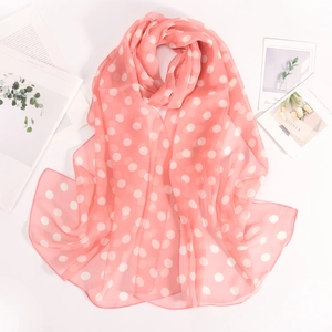 Piatto di sciarpa di seta rosa a pois su sfondo bianco con piante verdi fresche