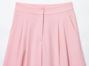 Detail of pink straight trousers showing double button waist and pleated front fabric