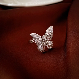 Macro de la bague papillon en zircon sur tissu de soie sombre montrant les détails