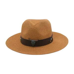 Détail d'un chapeau de paille beige avec bande en cuir, tête de taureau et broderies