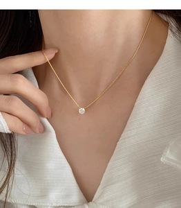 Classic round zircon pendant necklace worn by a model on a minimalist gold chain