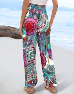 Back view of women's bohemian floral wide leg trousers with high waist on a beach