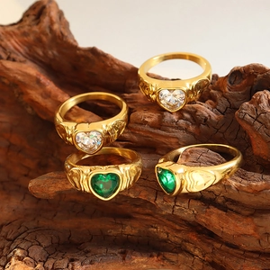 Vintage gold-plated heart-shaped glass stone rings with embossed texture on wood base