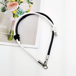 Detail of bicolor braided leather phone lanyard with metal clasps and decorative knot