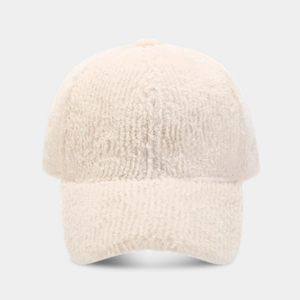 Vue détaillée de la texture douce en fausse fourrure sur une casquette crème