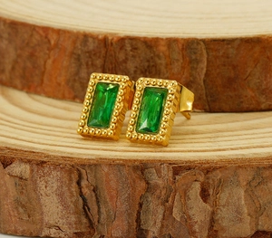 Gros plan de boucles d'oreilles en acier doré avec pierres rectangulaires vert émeraude