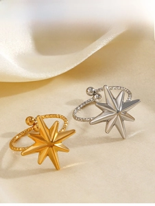 Dettaglio di orecchini a stella in oro 18K e argento su elegante raso beige