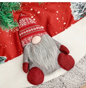 Close-up of a festive Christmas gnome decoration with red hat on a white plush surface