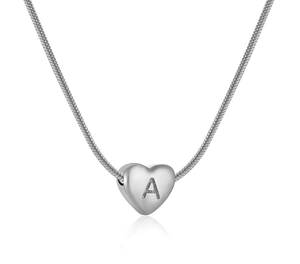 Dettaglio macro del ciondolo a cuore argento con incisione lettera A su catena snake