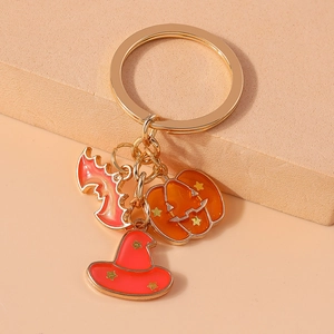 Close-up of Halloween keychain charms with pink bat pumpkin and red witch hat