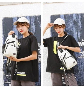 Close-up of white sports chest bag with multiple zippers and wide printed shoulder strap