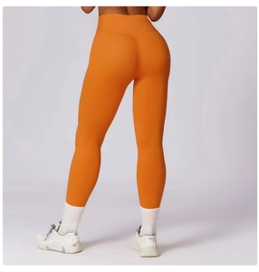 Rear view of vibrant orange high-waist yoga leggings showing slimming and butt-lifting effect