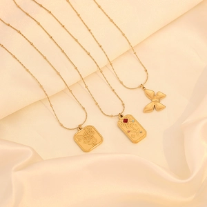 Vintage gold rose and tarot card necklaces with butterfly pendant on beige silk fabric
