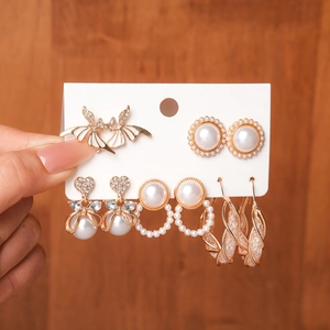Detail view of a 6-pair earring set featuring gold-plated bats, pearls, and heart charms
