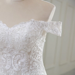 Detailed view of the off-the-shoulder lace wedding dress with shimmering sequins
