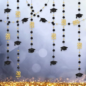 Detail of graduation party garlands with black glitter graduation caps and gold 2023 stars