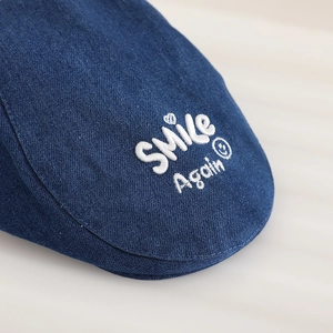 Navy blue denim beret for kids featuring white SMILE embroidery and twill texture