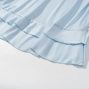 Detail of light blue tiered ruffle hem with delicate stitching on a bohemian long dress
