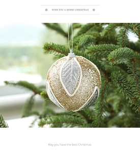 Detail of 8cm gold and silver glitter Christmas ball with leaf pattern on a tree branch