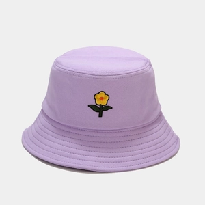 Dettaglio del ricamo a fiore giallo sul cappello da sole in cotone viola