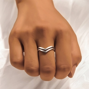 Detail shot of 925 sterling silver V-shaped rings styled on hand with a wave design