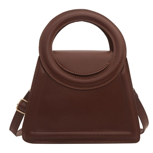 Minimalist dark brown trapezoid handbag with circular handle and adjustable strap