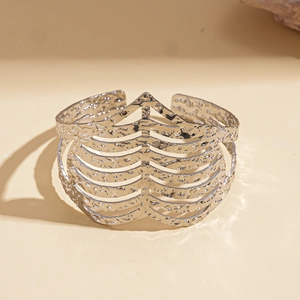 Detail of silver hollow heart-shaped cuff bracelet with hammered texture and rib design