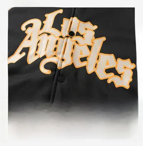 Detail of Los Angeles gradient graphic print and snap button on black hooded jacket