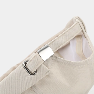 Detail of beige brimless cap with adjustable silver metal buckle and twill cotton fabric