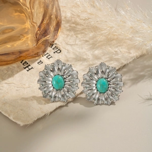 Macro shot of silver flower earrings with turquoise stone and sparkling rhinestones