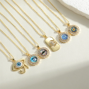 Detailed close-up of golden evil eye pendants with colorful enamel and zircon inlays