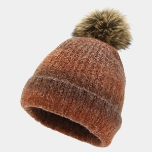 Detailed view of tie-dye knit beanie with fluffy faux fur pompom in caramel red tones
