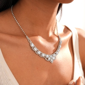 Close-up of silver-toned V-shaped necklace with leaf and flower motifs on a model