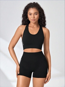 Detail of seamless black gymwear set with white text logo and high elastic fabric