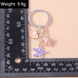 Detailed view of ocean themed keychain featuring seashell and starfish with ruler measurement