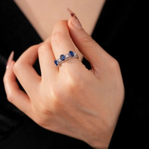 Gros plan détaillé d'une bague en dentelle argentée avec pierres bleues et zircons blancs