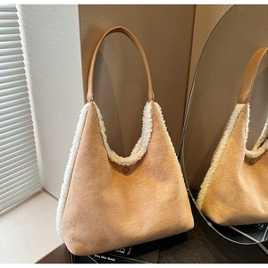 Detail of camel suede tote bag with white faux fur trim and leather strap design