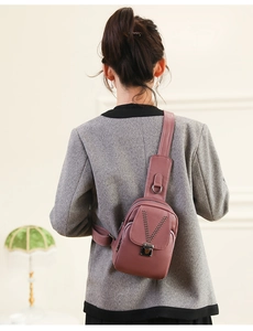 Détail du sac à bandoulière rose en simili cuir avec clous en V et boucle métallique