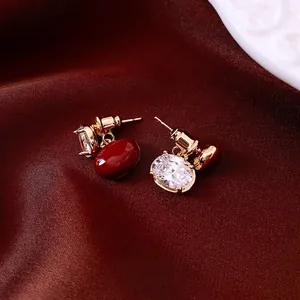 Boucles d'oreilles vintage dorées avec pierres ovales rouges sur satin élégant