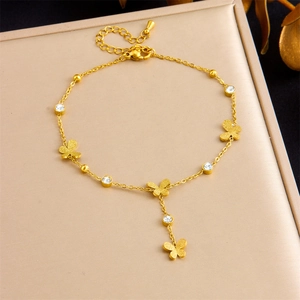 Détail d'un bracelet papillon doré avec zircons clairs sur un coffret à bijoux beige