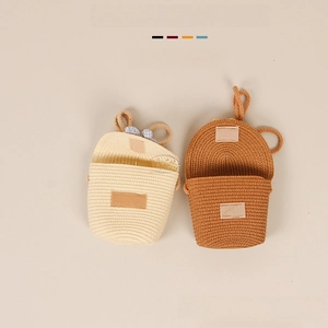 Detailed view of handmade woven straw bags for kids in cream and light brown colors