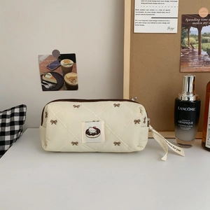 Close-up of quilted cosmetic bag with Hello Kitty donut patch and bow embroidery