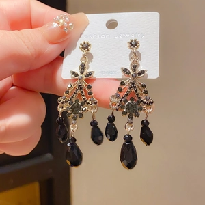 Macro detail of vintage gothic tassel earrings with black crystals and 925 silver needles