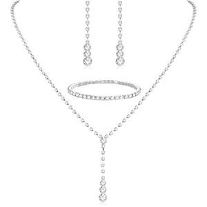 Detail view of silver bridal jewelry set with sparkling rhinestones on white background