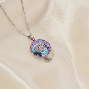 Silver chain necklace with a purple crystal coin pendant featuring a bow and key