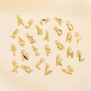 Set of 26 18K gold-plated DIY letter charms A-Z on light beige silk background